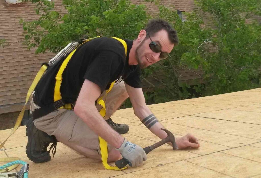 Person hammering on a roof.