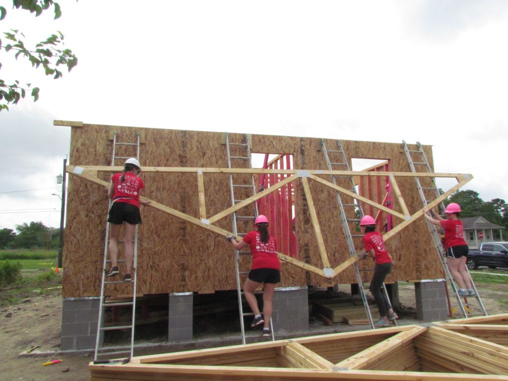 Volunteers lift a truss at Women Build 2019.