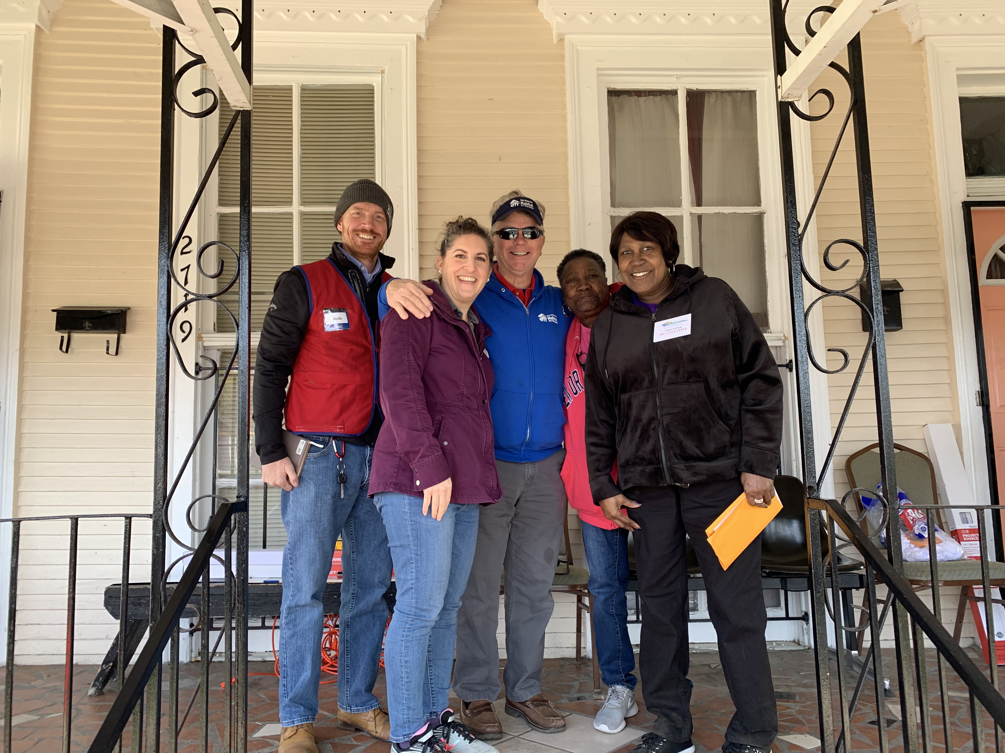A homeowner on her porch with the home repair team and friends.